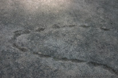 Aboriginal peg marks follow an outline in soft sandstone rock.
