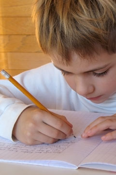 A young boy doing his homework.