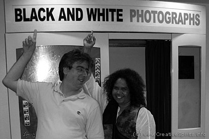 A white man and a black woman in front of a Black and white photography booth